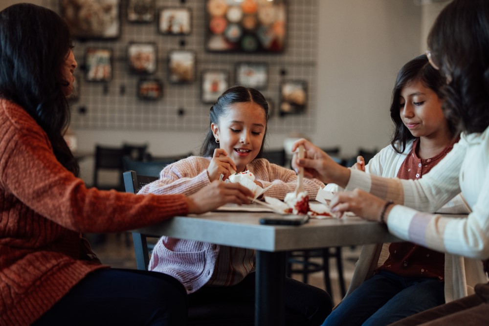 Mother and three girls enjoying cupcakes