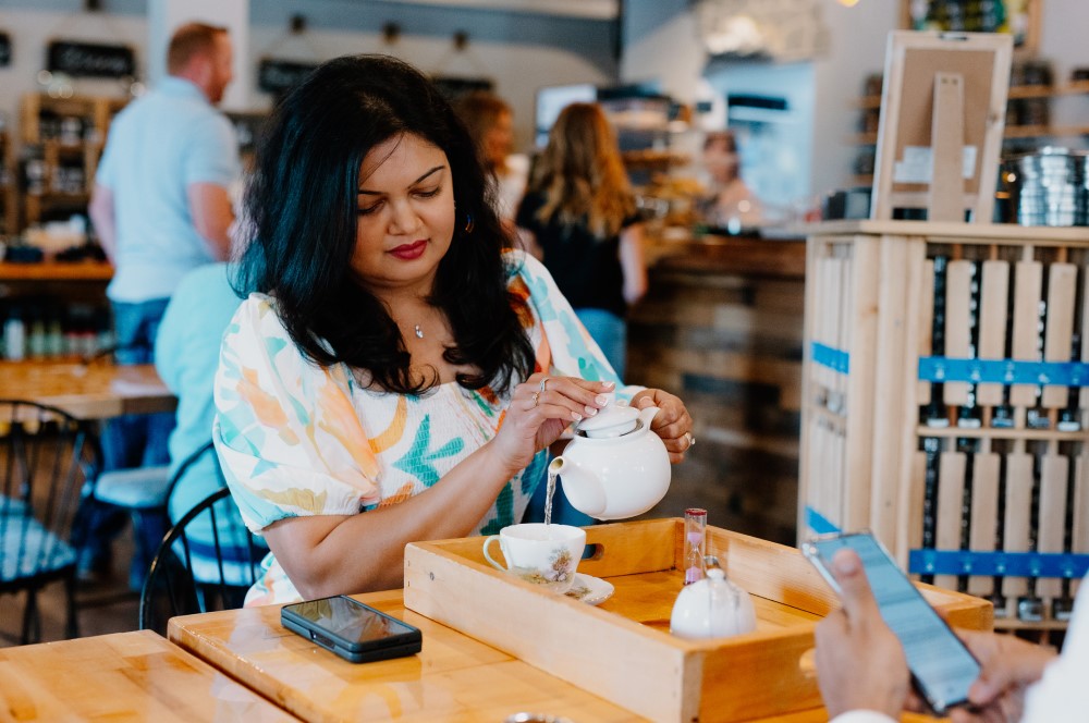 Woman at the Tea Cellar pour water into a tea cup